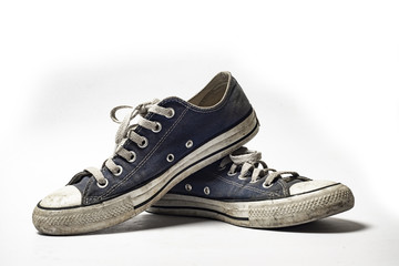 Dirty trainer canvas shoe on white background