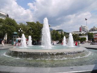 fountain in the city center on a background of a cloudy sky