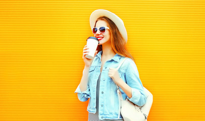 Cool girl drinks a coffee on a orange background