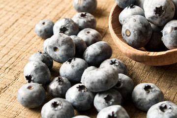 Fresh blueberries in a wooden spoon. On an old wooden table. The concept of natural food . Close up