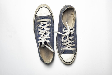 Dirty trainer canvas shoe on white background