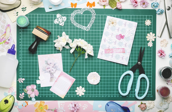 Paper Flowers, A Homemade Card And Tools For Scrapbooking On The Green Mat For Cutting. The View From The Top, No Hands