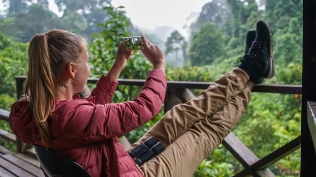 Cinemagraph of Female Tourist Sitting at Country House Terrace and Taking Mobile Photos of Nature. Active Tourism Concept