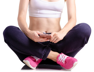 Woman in sports pants sneakers in the hands of a smartphone on a white background isolation