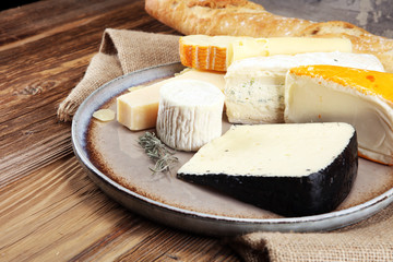 Cheese platter with different cheese on rustic plate