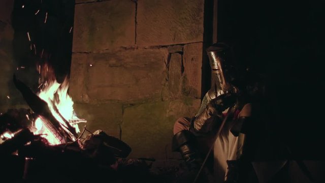 medieval crusader knight sharpening sword. historical documentary B-roll / film stock