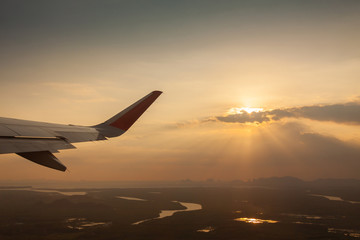 Wing of airplane flying above the field.