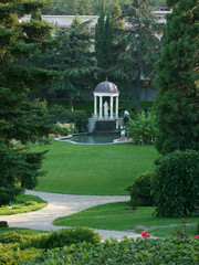 Obraz premium Monument statue under the dome near the lake in a green, clean park