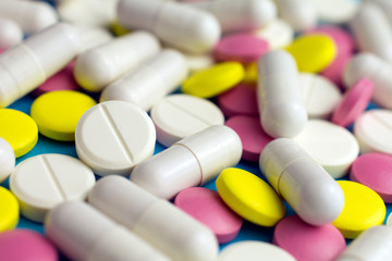 Heap of pills or tablets capsule plastic drugs bottle blue background. Drug prescription for treatment, Medicine pills Pharmaceutical medicament antibiotic, Pharmacy drugstore concept.