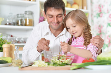 Father and daughter preparing salad