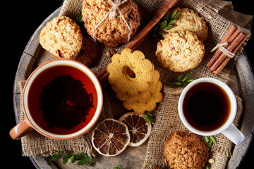 Christmas teatime with oatmeal, chocolate biscuits, and spices, on wooden background, close-up, selective focus.