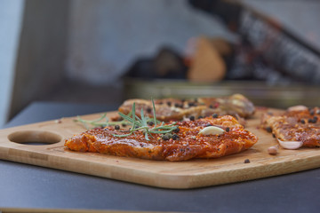Slices of raw pork meat with spices rosemary