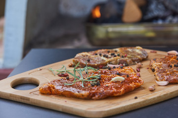 Slices of raw pork meat with spices rosemary