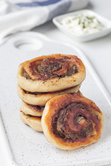 Fried savoury cottage cheese pies with minced meat on white plate, served with yogurt, vertical