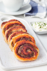 Fried savoury cottage cheese pies with minced meat on white plate, served with yogurt, vertical
