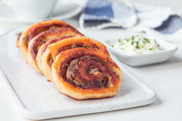 Fried savoury cottage cheese pies with minced meat on white board, served with yogurt, horizontal