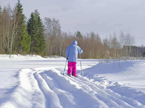 Cross-country skier skiing on classical style track. Fresh winter activity background.