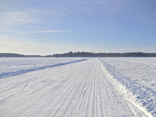 Fototapeta na wymiar Ice road on frozen snow covered sea in Finland.