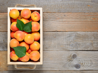 Apricots in box on wooden table