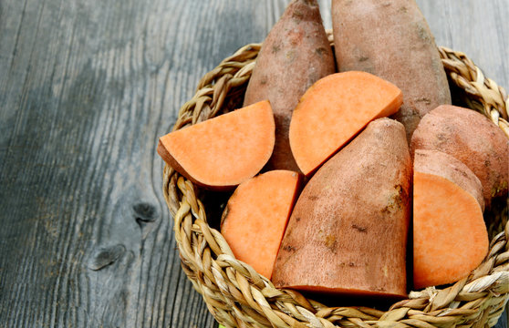Sweet potatoes are cholesterol-free and fat-free to provide an excellent food source to eat healthy.
Many Sweet potatoes in the basket with wooden background.