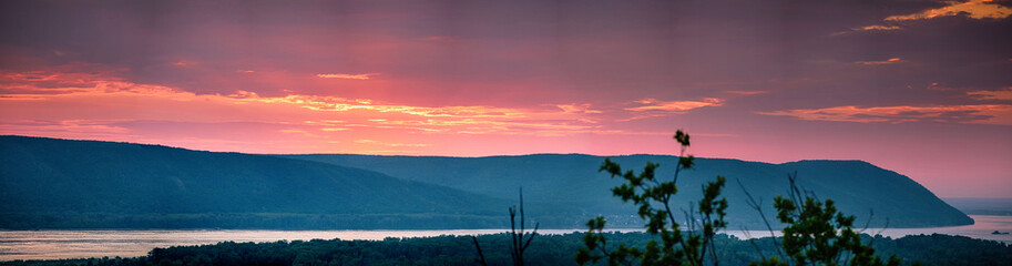 Dramatic sky during sunset over Volga river in front of hills near Samara city, Russia