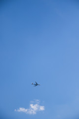 Image of flying airplane in clear sky with sun at background