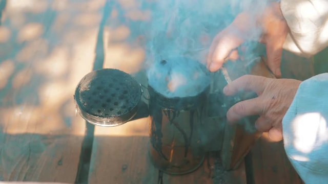 bee-maker of a smoke pipe beeper smoker device for repelling evil lifestyle bees. slow motion video apiary. beekeeping concept bee agriculture