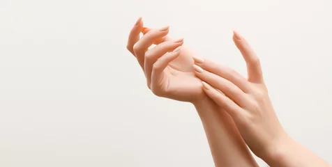 Foto op Plexiglas Mooie vrouw handen. Vrouwelijke Handen Toepassing Crème, Lotion. Spa en manicure concept. Vrouwelijke handen met french manicure. Zachte huid, huidverzorgingsconcept. Handverzorging. © looking2thesky