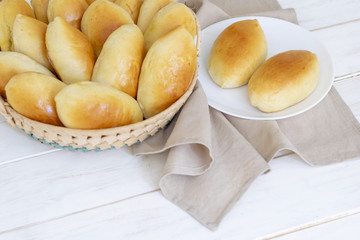 Beautiful homemade cakes with cabbage in a basket on a white wooden table, homemade cakes