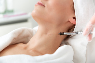 Obraz premium Optimistic female during treatment procedure. Cosmetologist hands in gloves introducing medication