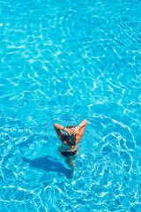 woman relaxing in infinity pool at luxury resort spa retreat.