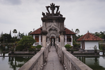 Obraz premium stone bridge in historical Bali hindu temple, surrounded by water