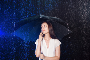 Young woman under umbrella. Protection from rain.
