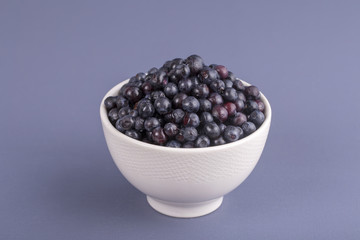 Healthy eating, food, dieting and vegetarian concept - fresh, ripe blueberries in bowl, wild berry, closeup. Fresh blueberry on gray background