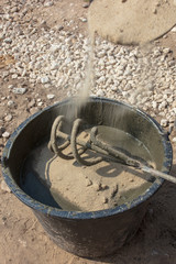 The worker mixes the concrete mixture at the construction site