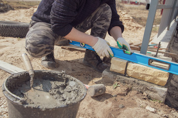 The worker lays bricks on the construction site