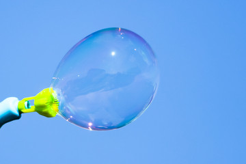 Soap bubbles in flight against the blue sky