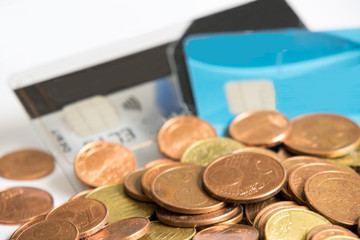 Zwei Kreditkarten im Hintergrund .Viele Euro Cent M&uuml;nzen im Vordergrund