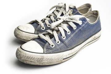 Dirty trainer canvas shoes on white background
