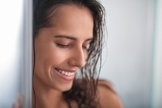 Close up female face with beautiful brilliant smile and wet curly hair