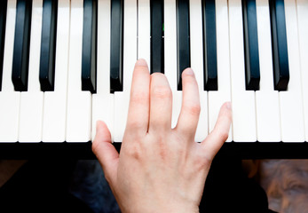 Woman's hand playing piano
