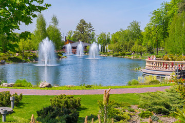 The park area with a lake and the backgrounds on it against the background of green trees and ornamental plants. Mezhigorye, Ukraine