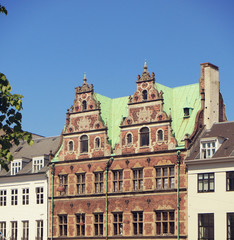 Fototapeta na wymiar Copenhagen, Denmark - facades in Dutch Renaissance style of a building in city center with the green copper roof cover characteristic of the city profile
