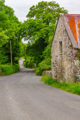 Stone house in a Road with trees and plants