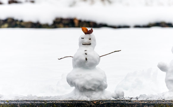 Hand made snowman, built with leaf and branch, at outdoor snow field in early winter season in Japan