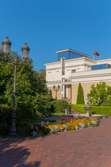 Obraz premium Park with a vintage metal lantern for lighting near the track on the background of the house