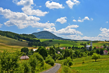 View of  grass fields,  church in Izby village and mountain Lackowa (997 msl) in Low Beskid (Beskid Niski), Poland - obrazy, fototapety, plakaty