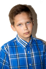 Portrait of a pensive boy in a blue shirt, on a white background