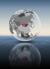 Fototapeta premium Mongolia on translucent globe above water