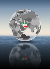 Iran on translucent globe above water